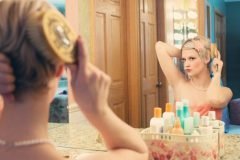 mujer peinandose en un espejo