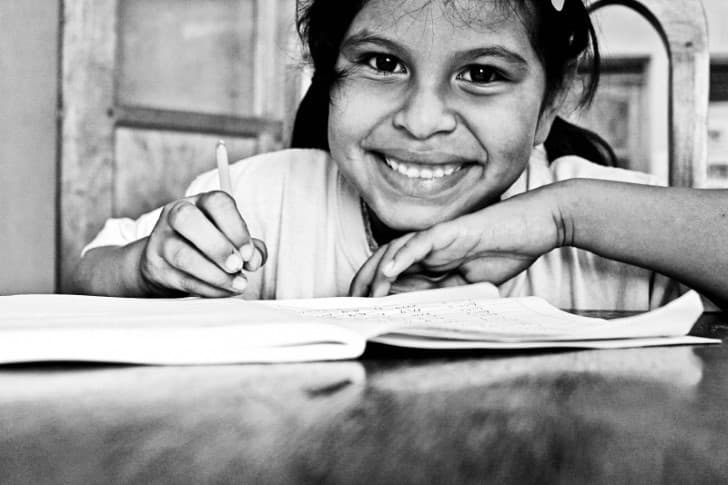 niña escribiendo con una sonrisa