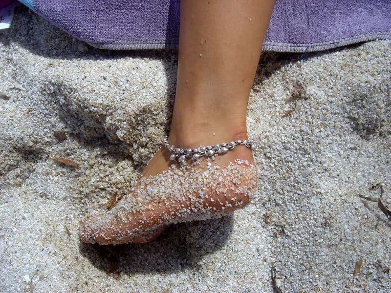 arena de playa en los pies