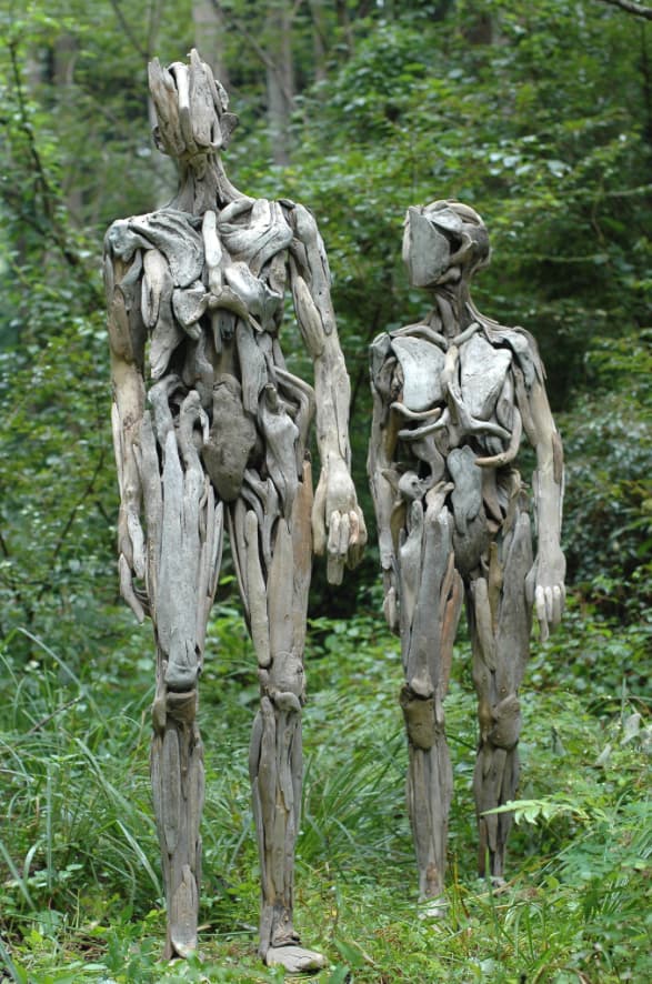esculturas humanoides de madera en el bosque